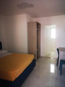 a bedroom with a bed and a closet and a table at Hotel Mare Blu in Torre dell'Orso