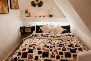 a bedroom with a bed with a quilt on it at Forsthaus-Ferienhotel am Dobrock in Wingst