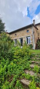 une maison en briques avec des buissons devant elle dans l'établissement Bienvenue aux Lavandières., à Montrollet