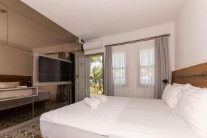 a hotel room with two beds and a television at Mükellef Gümüşlük in Bodrum City