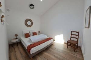 biała sypialnia z łóżkiem i krzesłem w obiekcie Mamita1"Apartment delight of the pines"spacious bright T3 62m18mterrace w mieście Lacanau +13 zdjęć