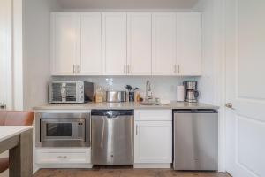 uma cozinha com armários brancos e electrodomésticos de aço inoxidável em NEW - Heart of SOHO. Minutes to Downtown/Stadium 2 em Tampa