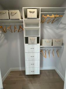 a closet with white drawers and hangers at Beautiful New Construction Ventnor Beach House in Ventnor City