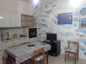 a kitchen with a table and a table and chairs at Villa Il Lupo in Pachino