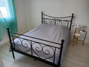 a bedroom with a black bed with a white comforter at Les Cyclades, T3 climatisé, terrasse, 500m plage in Le Grau-dʼAgde
