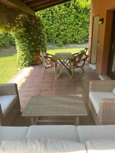 a patio with a table and chairs on a patio at Garda Golf Country Chic Home in Soiano del Lago