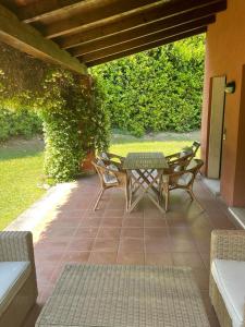 a patio with a table and chairs on a patio at Garda Golf Country Chic Home in Soiano del Lago