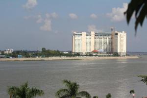 ein großes weißes Gebäude neben einem Wasserkörper in der Unterkunft New Season Riverside Hotel in Phnom Penh
