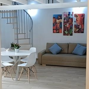 ein Wohnzimmer mit einem Sofa, einem Tisch und Stühlen in der Unterkunft Agata Blu in Catania