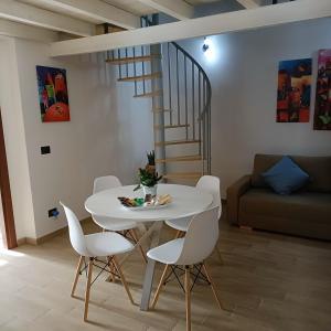 einen weißen Tisch und Stühle in einem Wohnzimmer mit einer Treppe in der Unterkunft Agata Blu in Catania