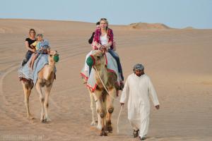 een groep mensen die op kamelen rijden in de woestijn bij Sky View in Jaisalmer