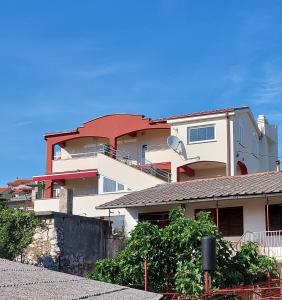 a large white building with a red roof at Apartments Laganini in Novi Vinodolski