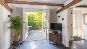 a living room with a television and a patio at B&B Zilverstad Huisje De Veerpoort in Schoonhoven