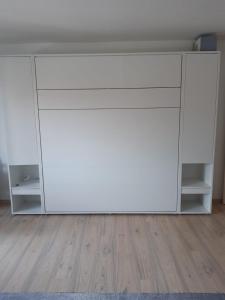 a white cabinet in a room with a wooden floor at Schöne Aussichten in Missen-Wilhams