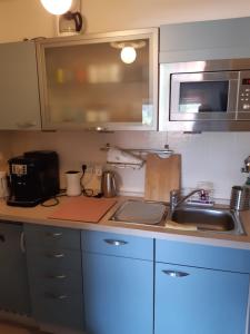 a kitchen counter with a sink and a microwave at Schöne Aussichten in Missen-Wilhams