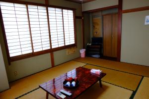 una sala de estar con una mesa en el centro de una habitación en Ichifujiso en Fujikawaguchiko