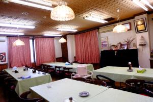a conference room with tables and chairs and chandeliers at Ichifujiso in Fujikawaguchiko