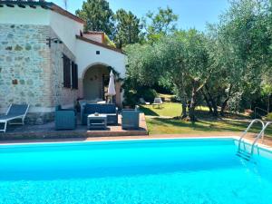 une villa avec une piscine en face d'une maison dans l'établissement Villa Fiorenzani, à Radicondoli