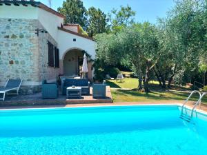 a villa with a swimming pool in front of a house at Villa Fiorenzani in Radicondoli