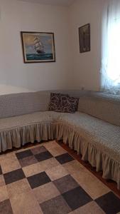 a couch sitting in a room with a window at Lemon Tree in Ulcinj