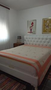 una camera con un grande letto con testiera bianca di Lemon Tree a Ulcinj