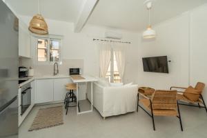 アテネにあるSunny And Cozy 2bd Apt 1 min from Marina Floisvosのソファとテーブルのあるキッチンとリビングルーム