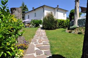 un jardin avec un chemin en pierre en face d'une maison dans l'établissement Gan Eden B&B, à Monterenzio