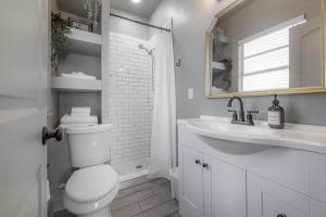 a white bathroom with a toilet and a sink at Updated Condo in Heart of Tampa in Tampa +11 photos