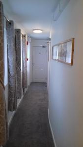 un pasillo con una puerta blanca con cortinas y una foto en Barclay Court Guest House, en Torquay