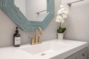 a bathroom sink with a bottle of wine and a mirror at Charming Updated Condo in Heart of Tampa in Tampa