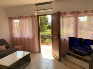 a living room with a couch and a tv and a window at Le Venise 3 Etoiles Frejus in Saint-Aygulf