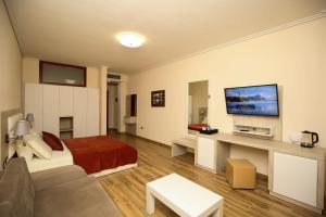 a large living room with a bed and a tv at Hotel VD Roleks in Vlorë +123 photos