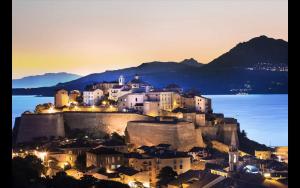 a town on top of a mountain at night at Farfalla in Calvi