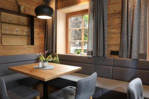 ein Esszimmer mit einem Tisch, Stühlen und einem Fenster in der Unterkunft Hotel Weiler - Aktiv & Tradition in Obertilliach