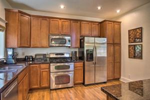 una cocina con armarios de madera y electrodomésticos de acero inoxidable en Flagstaff Hideaway Private Hot Tub, 4 Mi to Dtwn!, en Flagstaff