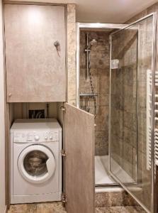y baño con lavadora y ducha. en Le Lodgy - Cœur de la Vieille Ville - Majord'Home, en Annecy