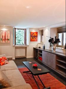 sala de estar con sofá y mesa en Le Lodgy - Cœur de la Vieille Ville - Majord'Home, en Annecy