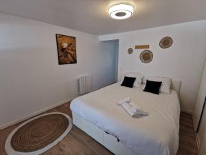 een slaapkamer met een wit bed in een kamer bij La petite Halte - Les Maisons de Madeleine in Bouguenais