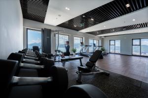 a man in a gym with chairs and treadmills at Armin Homes Altara Residences Quy Nhon in Quy Nhon