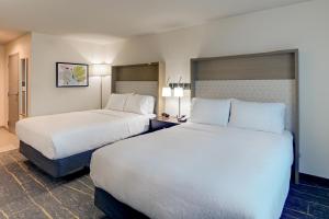 two beds in a hotel room with white pillows at Holiday Inn Mobile Airport, an IHG Hotel in Mobile