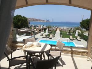 un patio con mesa, sillas y piscina en Blue Horizon Villa & Suites, en Sitia