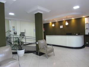 a lobby with a waiting room with chairs and a counter at Hotel Monteneve in Sao Paulo