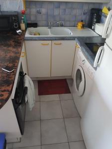 a kitchen with a sink and a washing machine at Appartement T2 pour 4 personnes in Plage dʼArgelès