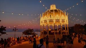 a crowd of people standing around a gazebo at night at Villa Olivia in Tricase
