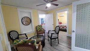 a living room with chairs and a clock on the wall at Lovely rental unit with free parking on premises in Clearwater
