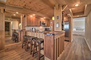 a kitchen with wooden cabinets and a bar with stools at Welcoming Brigantine Condo with Ocean Views! in Brigantine