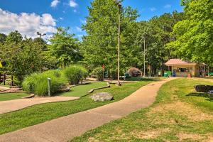 a path in a park with trees and a building at Fairfield Bay Condo with Patio Less Than 5 Mi to Lake! in Fairfield Bay
