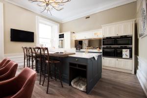 a kitchen with a black island with a fireplace at Linen House in Kelso