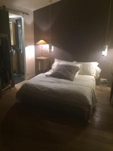 a bedroom with a bed and a lamp on a table at Chez Sylvie in Saint-André-des-Eaux +2 photos