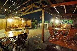 a restaurant with wooden tables and chairs in a room at Pose In Hotel Solo in Solo